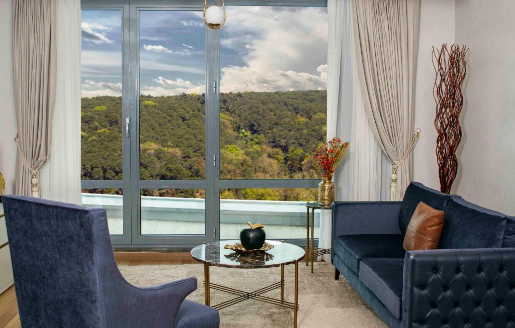 a living room with a blue couch and a large window at Maslak Aparts in Istanbul