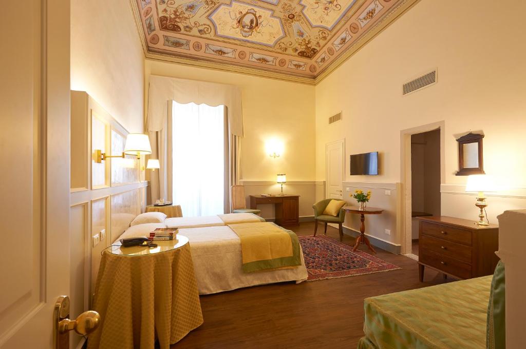 Hotel Firenze Capitale في فلورنسا: غرفة الفندق بسرير وسقف