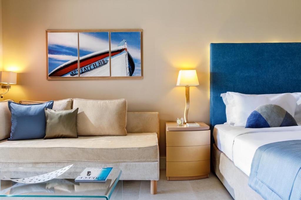 a hotel room with a bed and a couch at Daios Cove in Agios Nikolaos