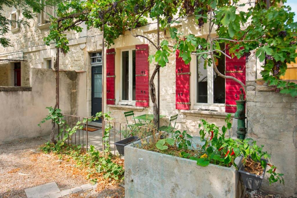 uma casa velha com tinta vermelha ao lado em Mini maison studio Ancienne Rénovée +Parking em Avignon