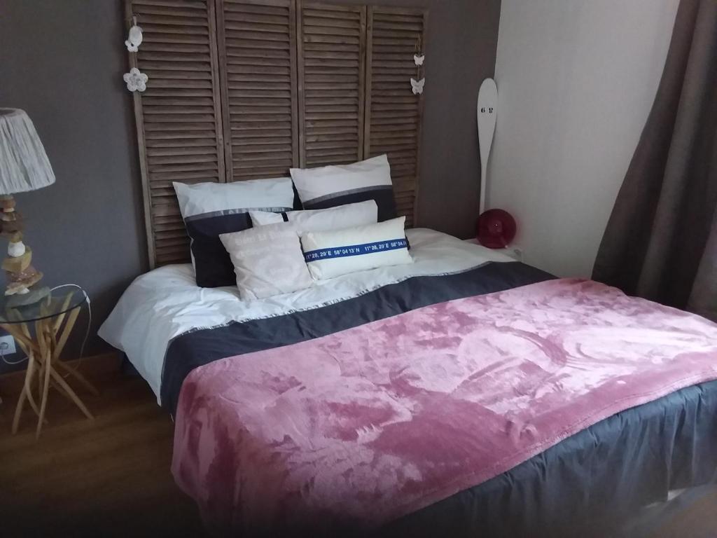 ein Schlafzimmer mit einem großen Bett mit Kissen darauf in der Unterkunft LES BIGORNEAUX in Saint-Suliac