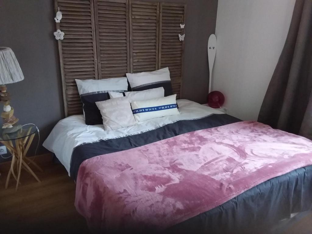 a bedroom with a large bed with pillows on it at LES BIGORNEAUX in Saint-Suliac