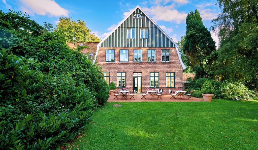 a large brick house with a lawn in front of it at Hotel & Restaurant Ole Liese in Panker
