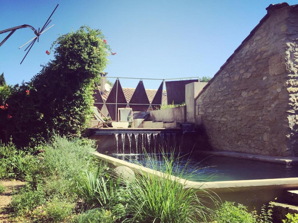 a water feature in a garden with a waterfall at M&S - Maison FÉRAUD in Saint-Rémy-de-Provence