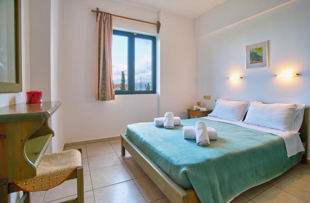 sypialnia z łóżkiem z ręcznikami w obiekcie Dionysos Apartments & Studios w mieście Stalida