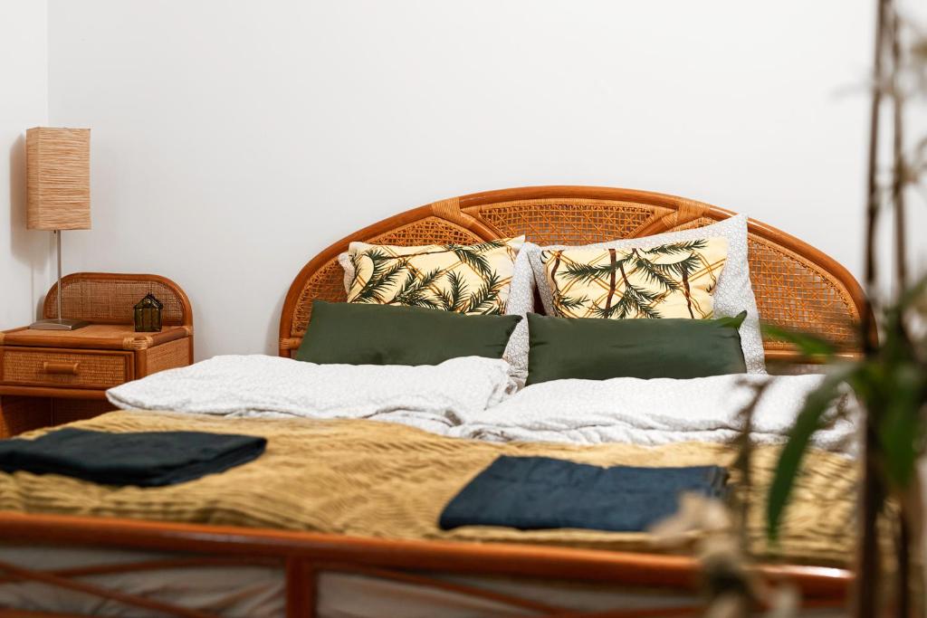 een bed met een houten hoofdeinde en kussens erop bij Negroni Apartments Stare Miasto in Krakau