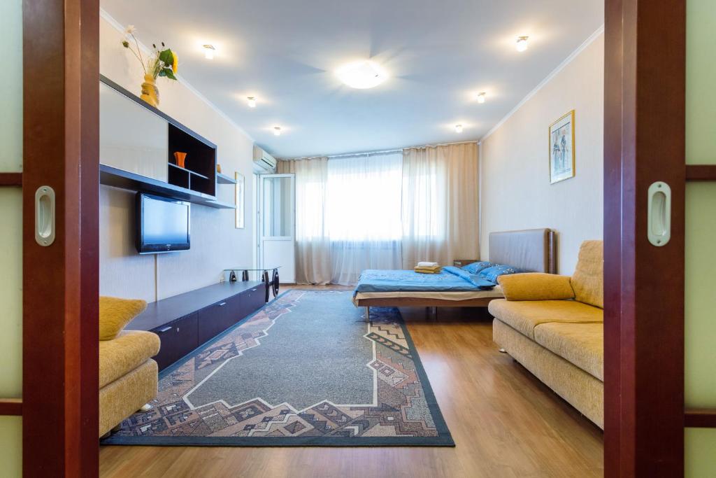 a living room with a couch and a tv at Apartments on Darnitsa in Kyiv