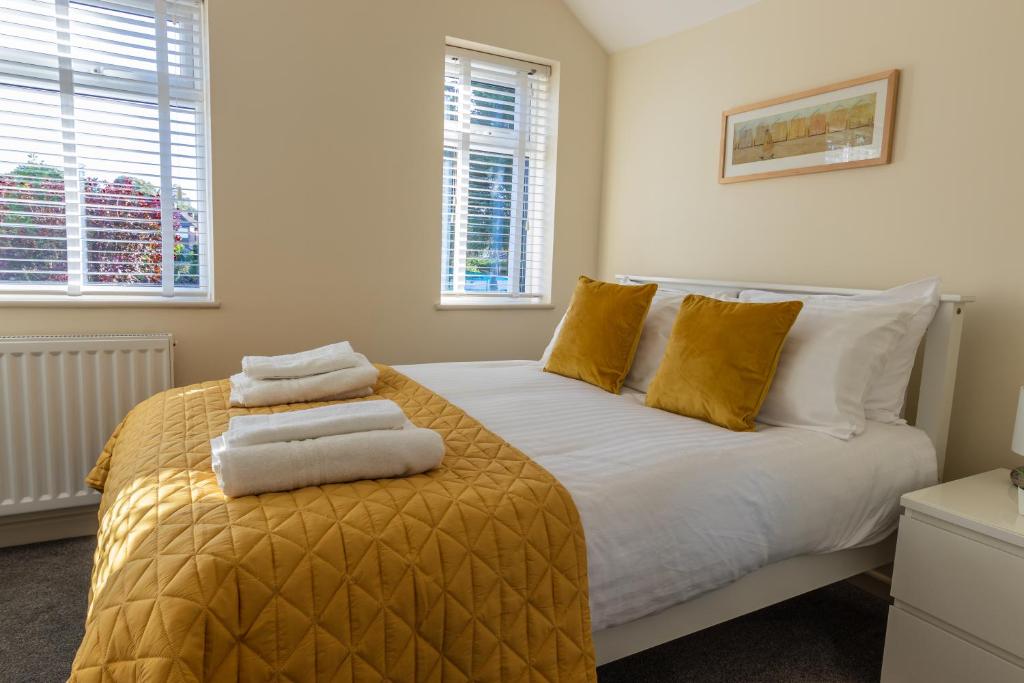 sypialnia z łóżkiem z ręcznikami w obiekcie Merewood House w Oksfordzie