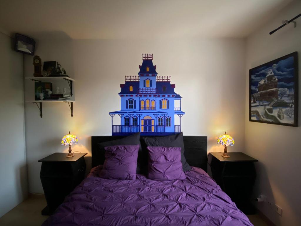 a bedroom with a purple bed with a blue building on the wall at Appartement FrontierHome à deux pas de Disneyland in Bailly-Romainvilliers