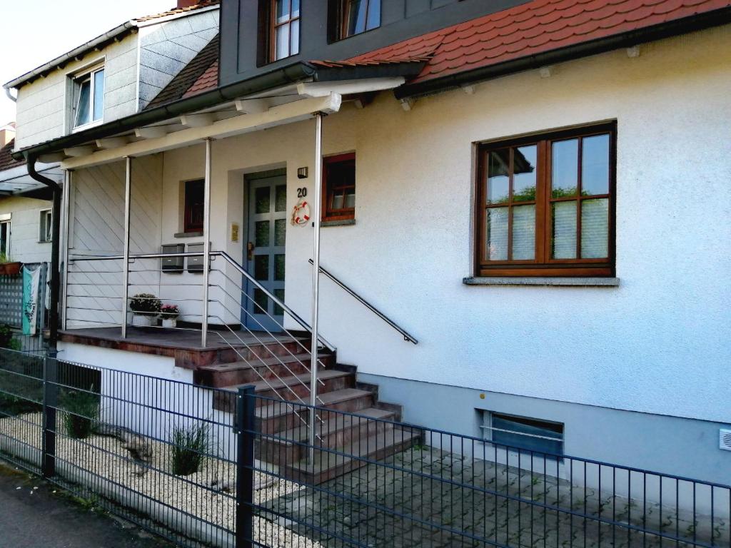 una casa blanca con una valla delante en Casa Kühnle en Friedrichshafen