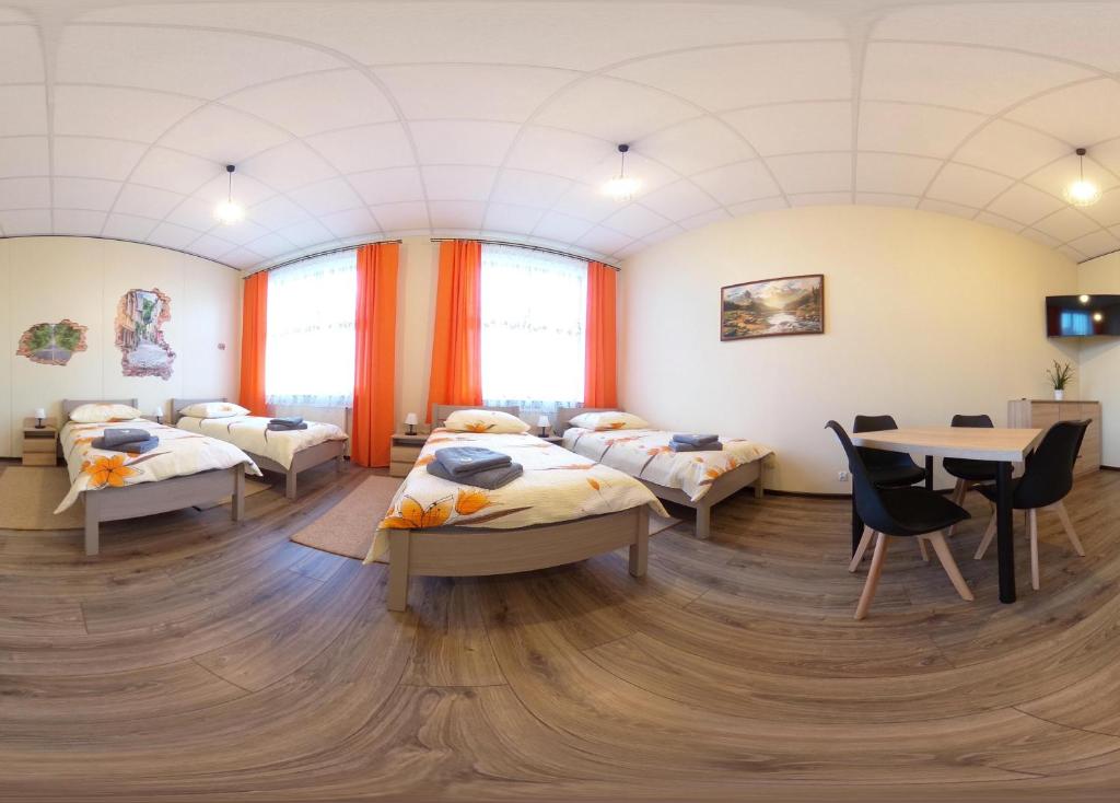 OlszynaにあるPokoje nad Nysą Olszynaの病室にはベッド4台とテーブルが備わります。