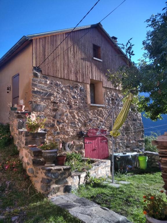 an old stone building with plants in front of it at Le Seuil De Mes Reves in Le Lauzet-Ubaye