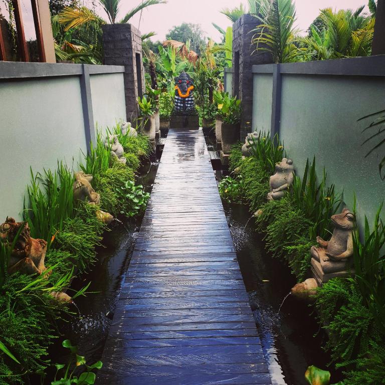 a walkway through a garden in a building at Ubud Season Villas in Ubud