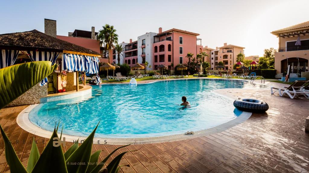 una persona nadando en una piscina en un complejo en Greice Homes-Luxury 2 bed en-suite south facing & Golf view, en Quarteira