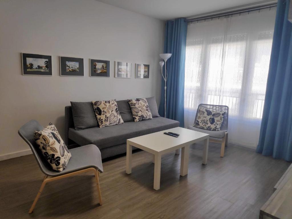 ein Wohnzimmer mit einem Sofa, einem Tisch und Stühlen in der Unterkunft SUITEDREAMS - Av. Fener in Andorra la Vella