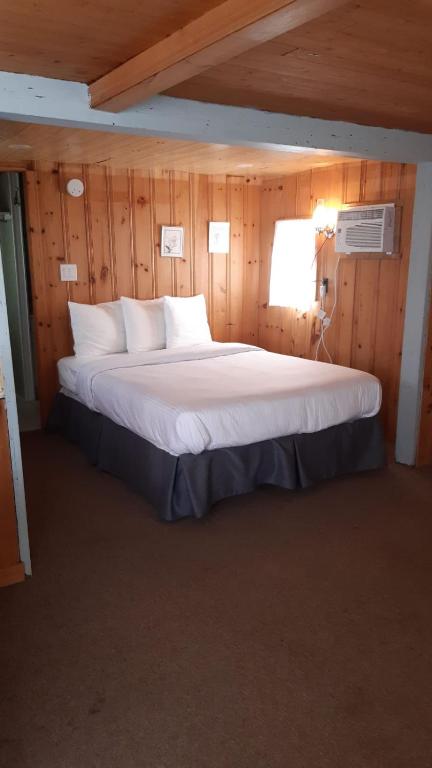 Una cama o camas en una habitación de Algonquin Lakeside Inn