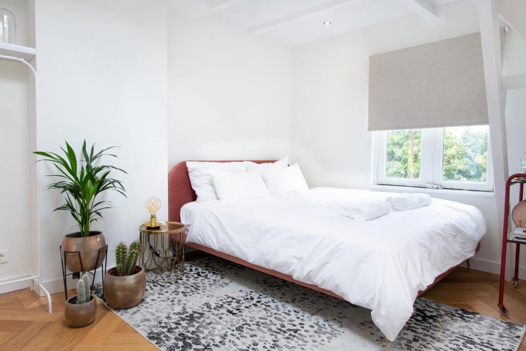 a bedroom with a white bed and a window at Trendy 2 bedroom accommodation on perfect location in Amsterdam