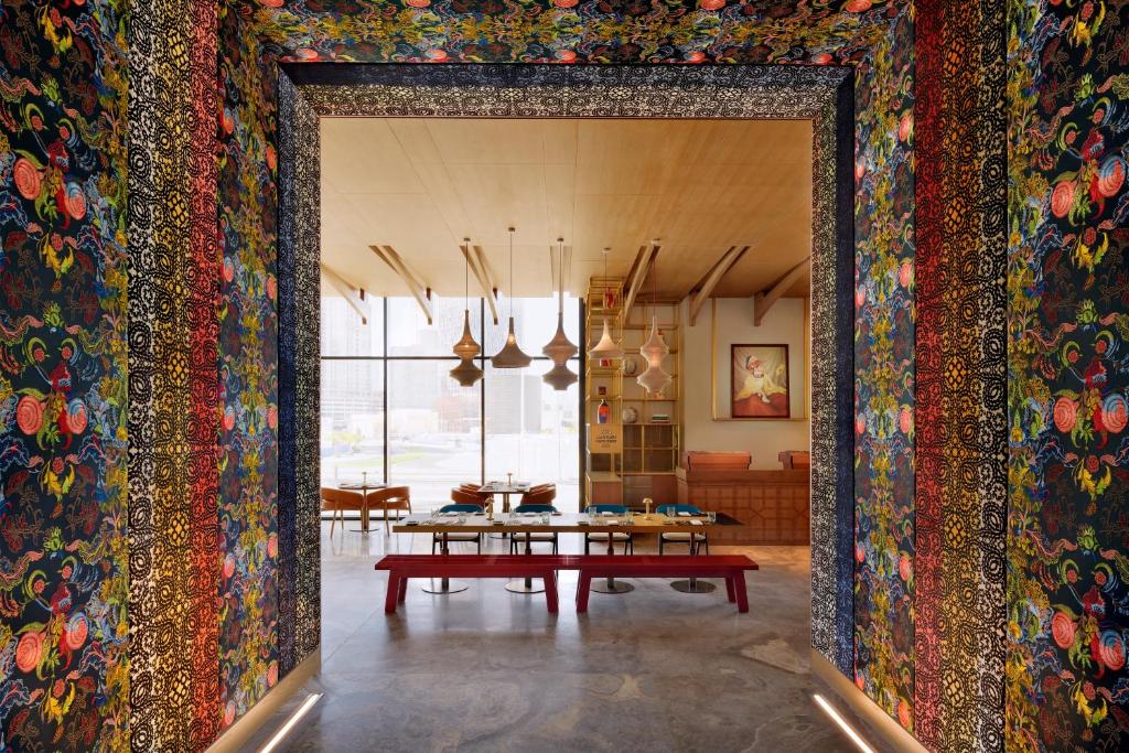 a room with a table and a wall covered in colorful carpet at Hotel Indigo Dubai Downtown, an IHG Hotel in Dubai