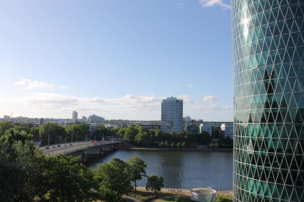 Blick auf eine Stadt mit einem Fluss und einem Gebäude in der Unterkunft ibis Frankfurt Centrum in Frankfurt am Main