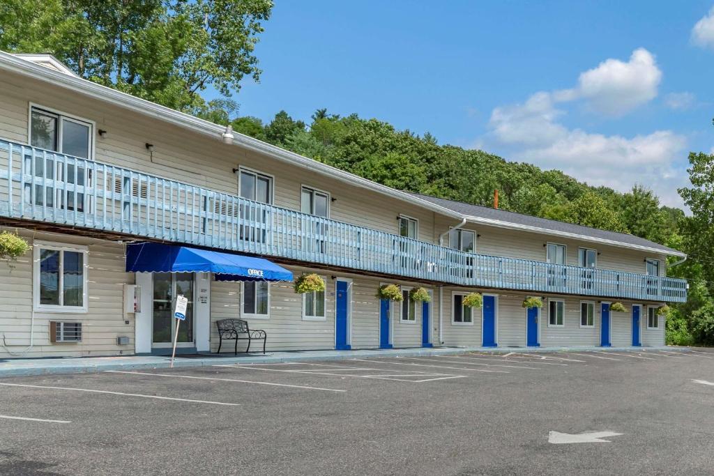 un gran edificio con columnas azules y balcones. en Econo Lodge Lee - Great Barrington, en Lee