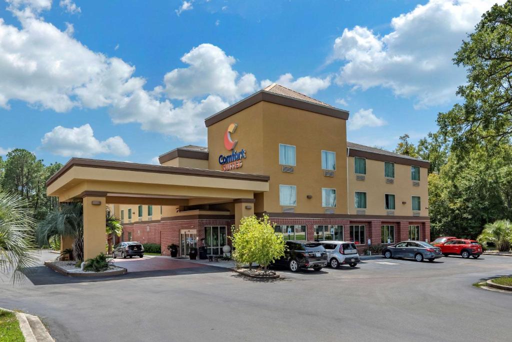 un hotel con coches estacionados en un estacionamiento en Comfort Suites Biloxi/Ocean Springs en Biloxi