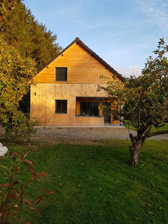 een houten schuur met een boom ervoor bij Gîte Côté Prairie classé 4 etoiles in Épagne-Épagnette