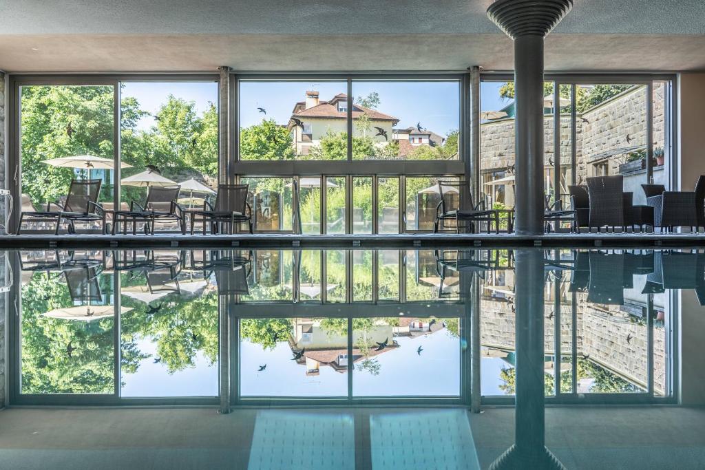 Blick auf den Pool von einem Gebäude mit Fenstern in der Unterkunft Hotel Bemelmans-Post in Klobenstein