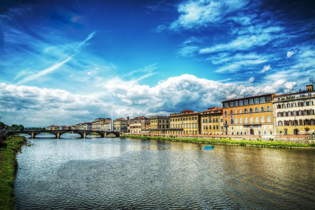 un río en una ciudad con un puente y edificios en Palazzo Alfieri Residenza D'Epoca - Alfieri Collezione en Florence