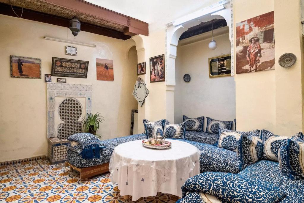 a living room with blue couches and a table at Family Room for 6 peoples Sunny Riad Inside Medina Fes El Bali in Fez