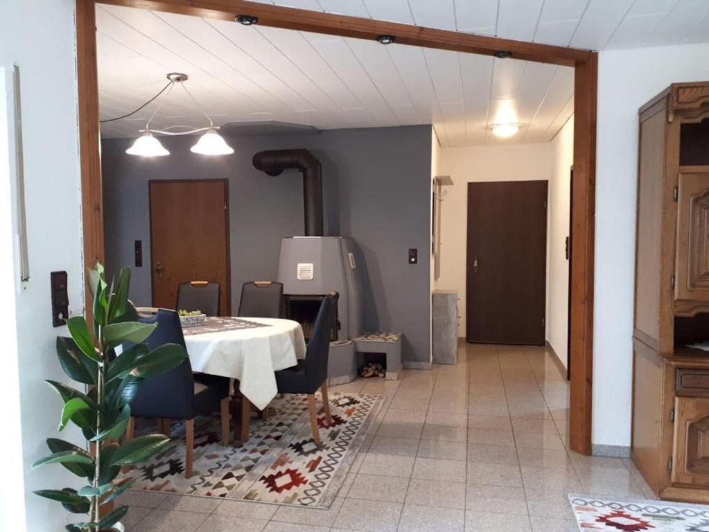 a dining room with a table and blue chairs at Ferienhaus Sonnenhang in Scheiden