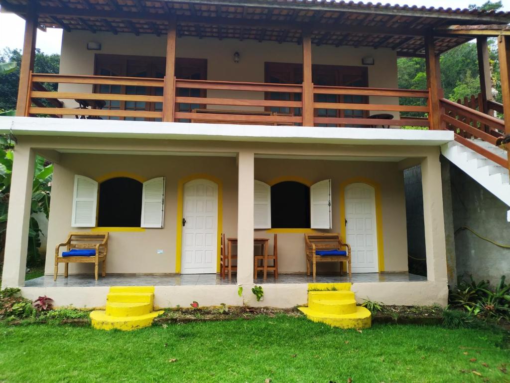 a house with two chairs and a balcony at Estalagem São Gonçalo in Tarituba