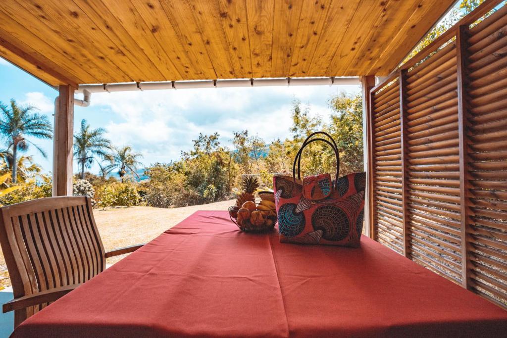 a red table with a basket on top of it at Saint Leu - Bungalow avec PDJ piscine vue mer et montagne - Bardzour in Saint-Leu
