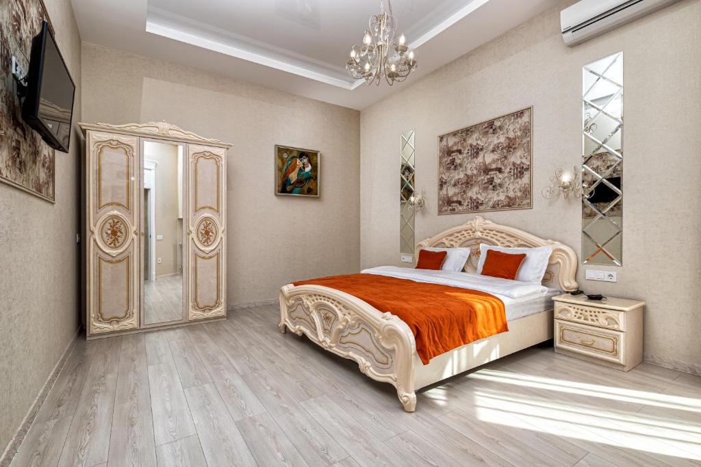um quarto com uma cama grande e um lustre em 2 bedroom apartment Tykha street city center with parking place em Lviv