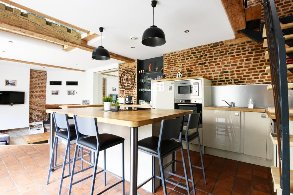 uma cozinha com uma mesa de madeira e cadeiras em MAISON VIEUX LILLE 3 chambres parking privé 24H24H Accès em Lille