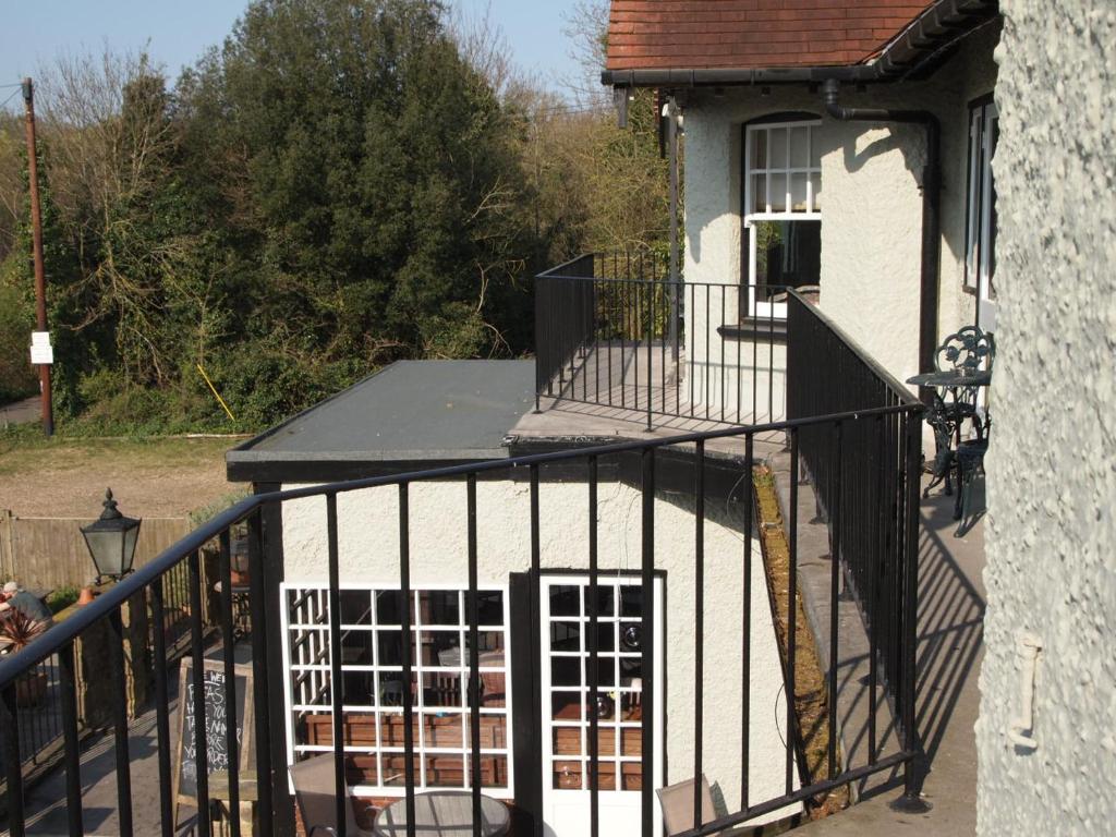 a white house with a black wrought iron gate at The Weir Hotel in Walton-on-Thames