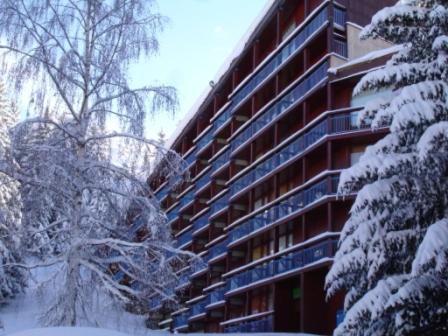 a snow covered apartment building with snow covered trees at Les Lauzières in Arc 1800