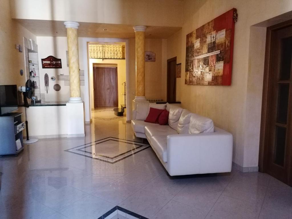 een woonkamer met een witte bank in een kamer bij Carini Luxury Apartment vicino aereoporto e al mare in Carini