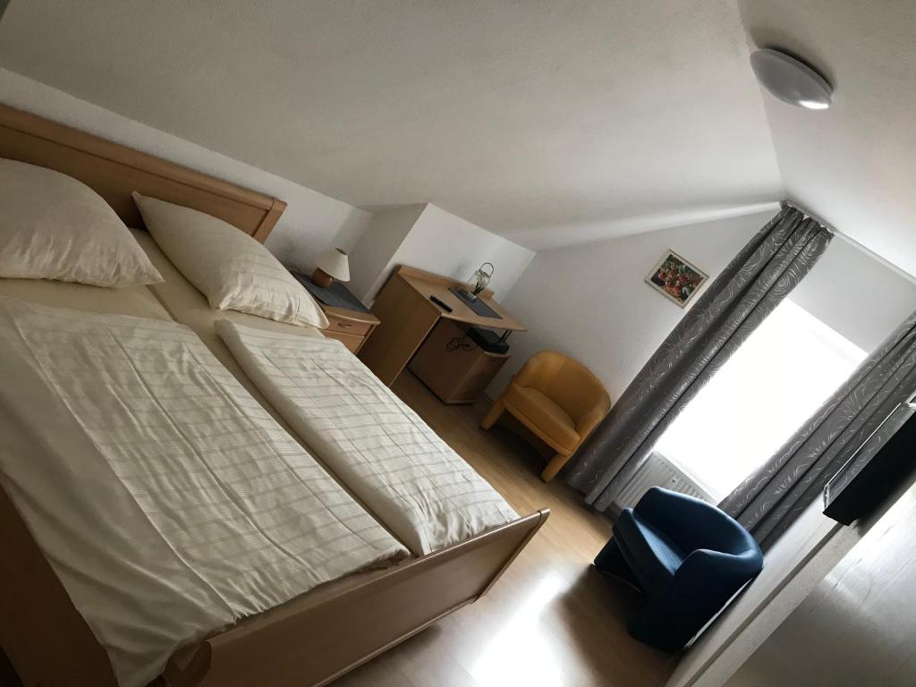 a small bedroom with a bed and a window at Pension Da Enzo in Otterbach