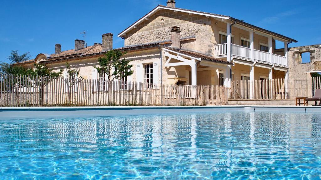 una casa con piscina di fronte a una casa di Domaine de Gorre a Martillac