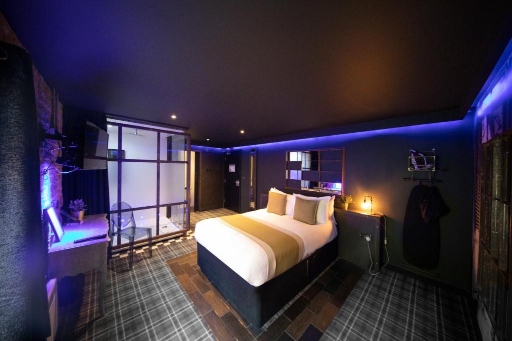 a bedroom with a bed with blue lights in it at Briggate Hotel in Leeds