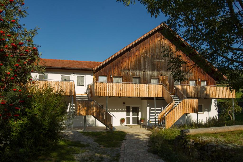 un gran edificio de madera con escaleras que conducen a él en Naturlaub.pur, en Waldmünchen