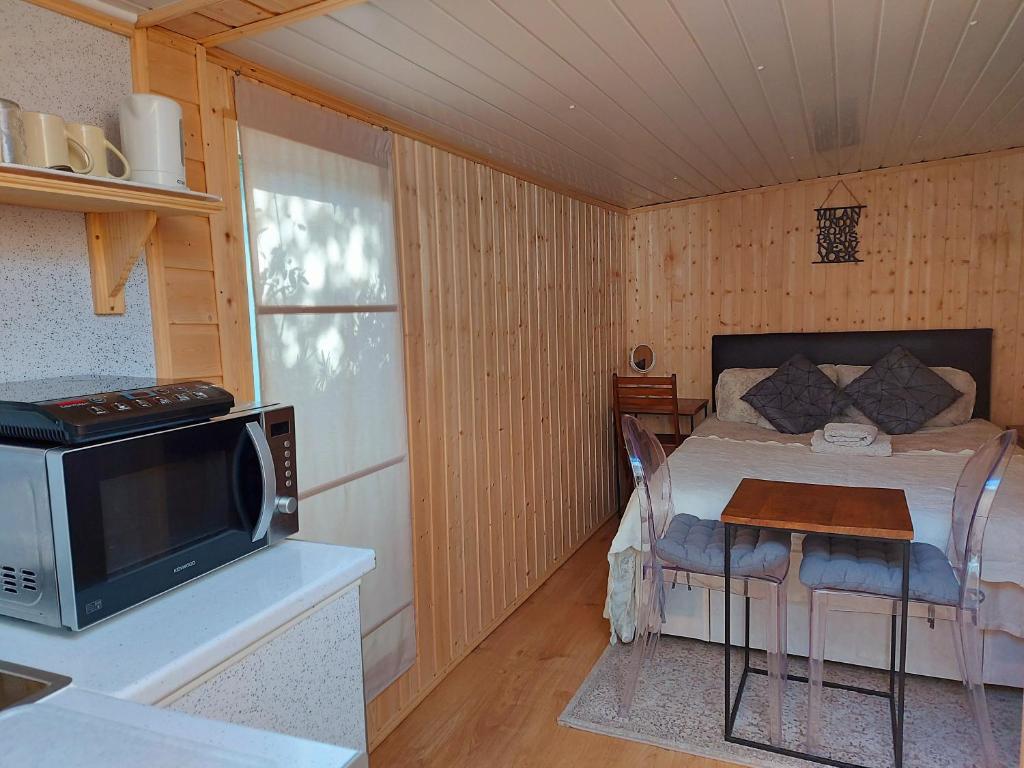 Kleines Zimmer mit einem Bett und einem Tisch mit einer Mikrowelle. in der Unterkunft Pretty Studio with a Private Terrace in London