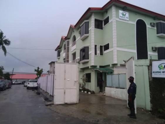 a man standing in front of a building at Alluring View Hotel - Toyin Sreet in Ikeja