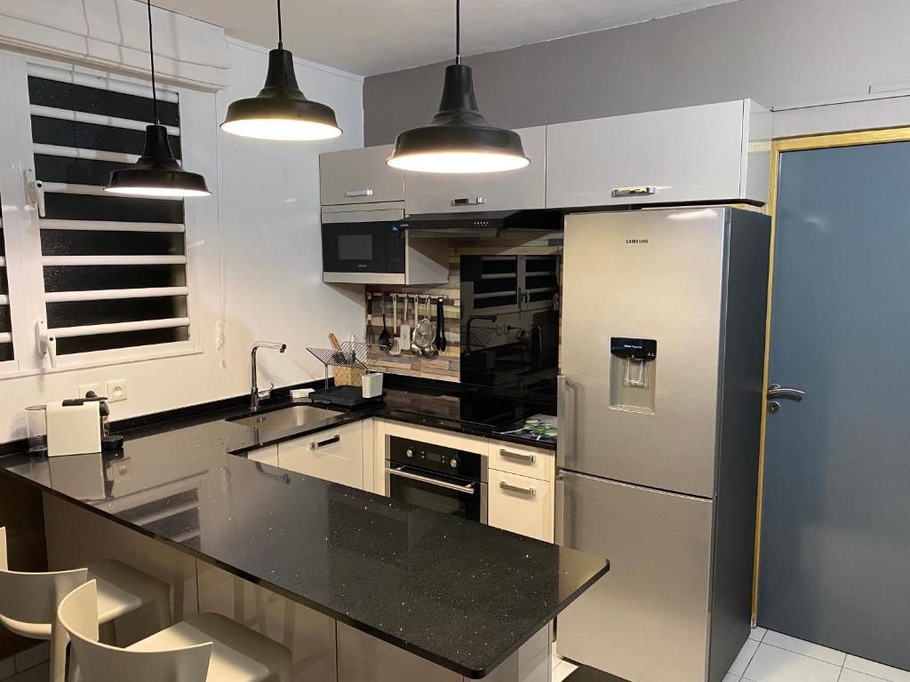 舍尔谢Appartement F3 de standing A Schoelcher的配有不锈钢冰箱和橱柜的厨房