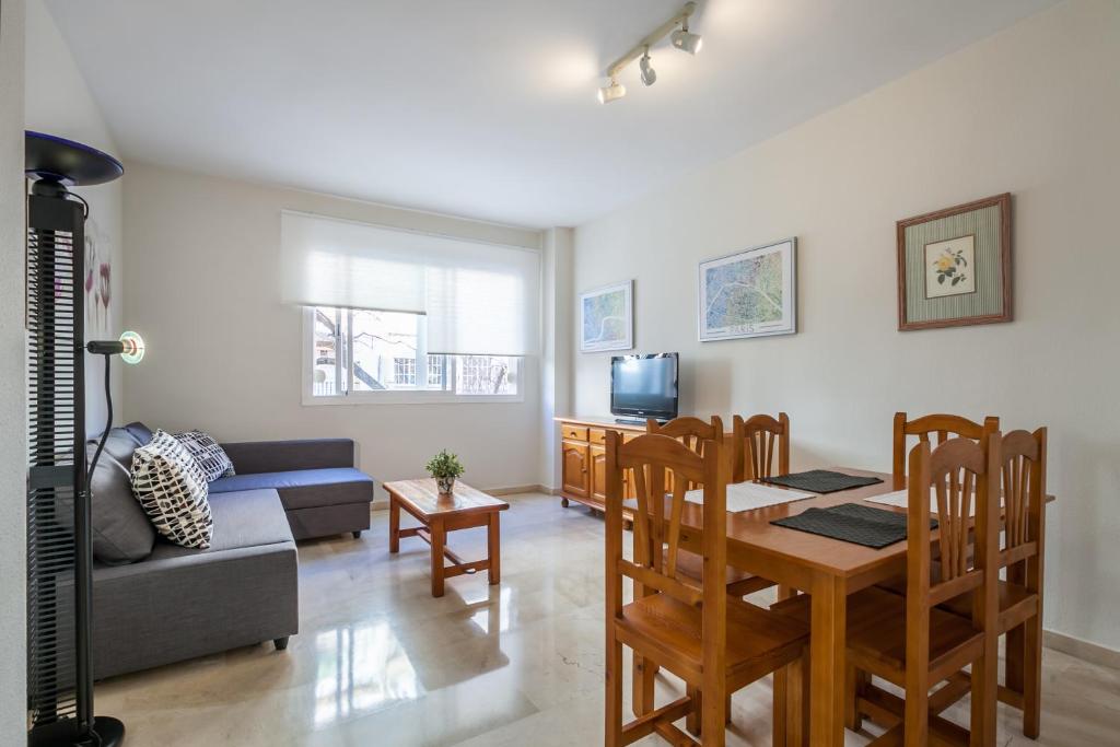 - un salon avec une table et un canapé dans l'établissement Apartamento cerca del Alcázar con garaje privado, à Séville