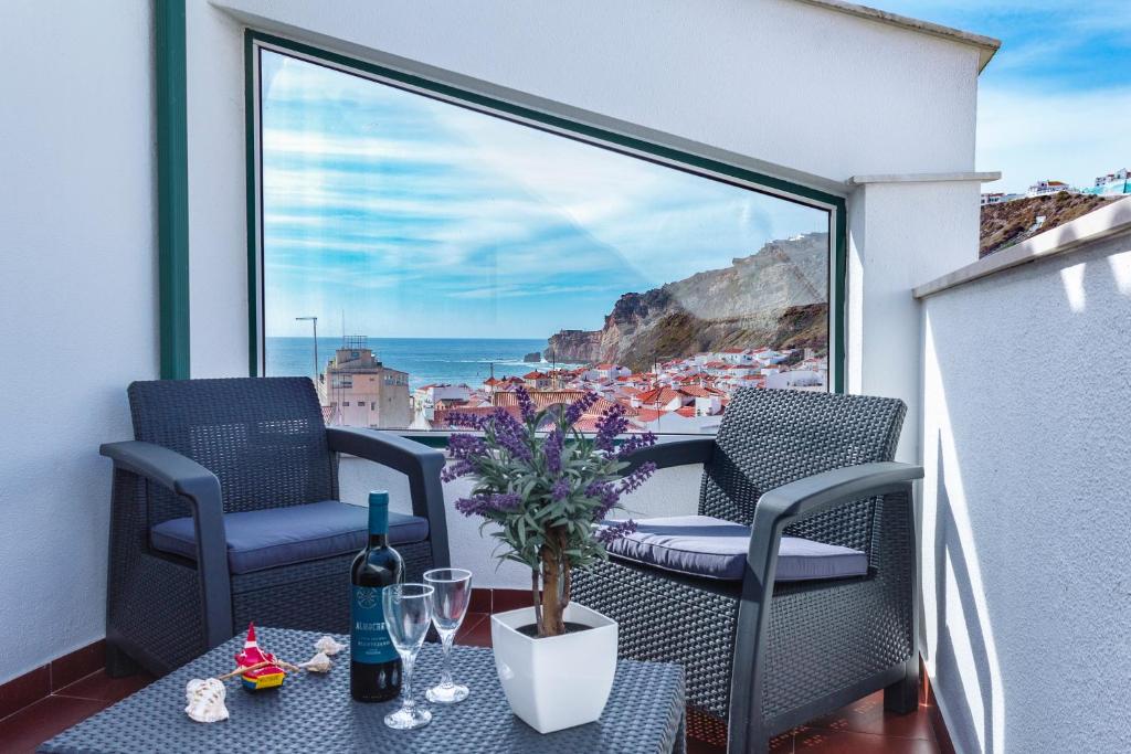 een balkon met stoelen en een tafel met uitzicht op de oceaan bij Varandas da Tia Guida in Nazaré