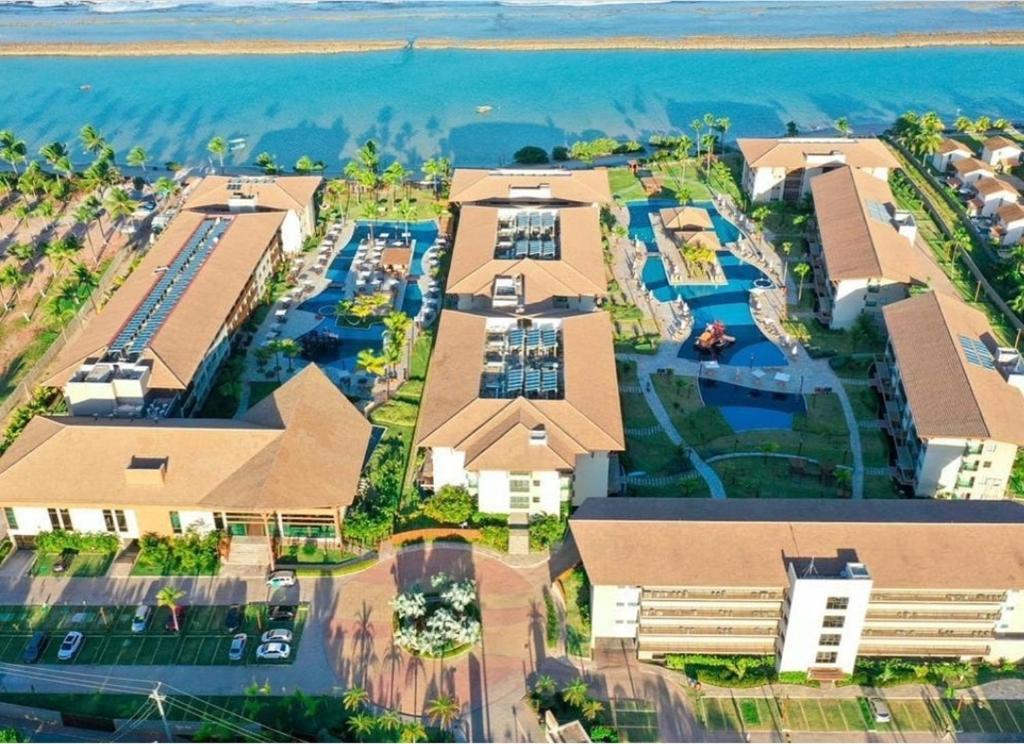 an aerial view of a resort with the ocean in the background at La Fleur Polinesia Residence & Resort in Porto De Galinhas