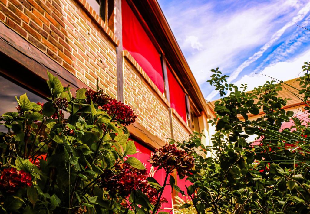 a brick building with a plant in front of it at Auberge de la Vieille Ferme in Le Meux