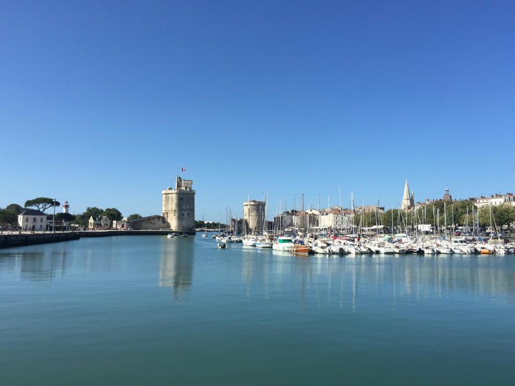 a group of boats in a harbor with a city at VOILIER ESTEREL in La Rochelle
