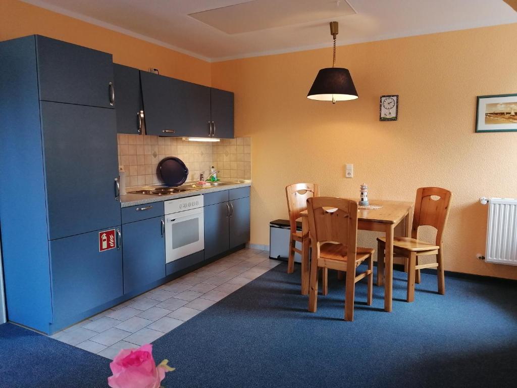 a kitchen and dining room with a table and chairs at Gasthof-Ferienwohnungen-Kliesow´s Reuse in Alt Reddevitz